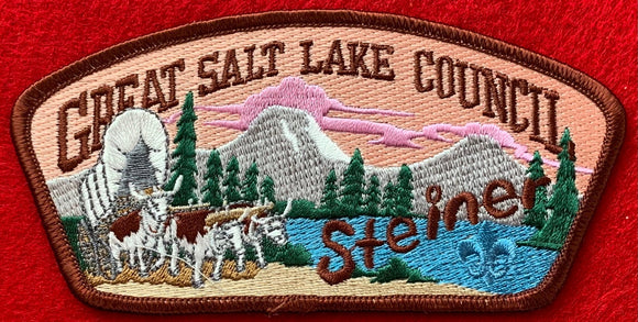 Great Salt Lake Council Camp Steiner CSP SA-133. Embroidered Bull-Drawn Covered Wagon with Wooded Mountain Lake Background. Brown Camp Steiner Logo Detail. Brown Border. Mint Condition.