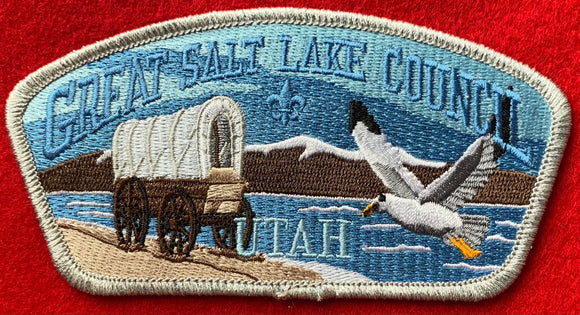 Great Salt Lake Council CSP SA-276. Embroidered Covered Wagon and Flying Seagull infront of Mountain Lake Landscape. Silver Mylar Border. Mint Condition.