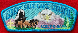 Great Salt Lake Council Scout-O-Ree Commerative CSP SA-53. Embroidered Bull-Drawn Covered Wagon Infront of Mountain with Superimposed Bald Eagle Face Background. Light Blue Border. Mint Condition.