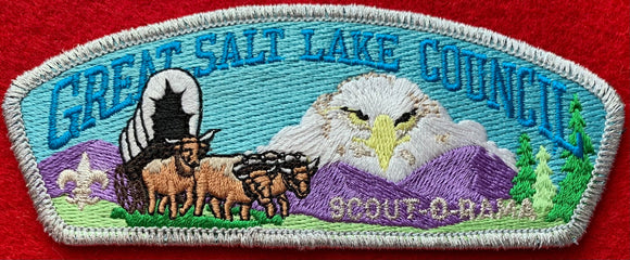 Great Salt Lake Council Scout-O-Ree Commerative CSP SA-54. Embroidered Bull-Drawn Covered Wagon Infront of Mountain with Superimposed Bald Eagle Face Background. Silver Mylar Border. Mint Condition.