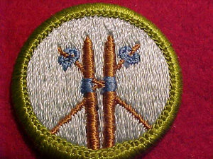 SKIING, MERIT BADGE WITH CLEAR PLASTIC BACK, GREEN BORDER, NO IMPRINTS/LOGOS IN PLASTIC, 1972-79, BROWN SKIS