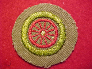 AUTOMOBILING MERIT BADGE (SPOKED WHEEL), CRIMPED EDGE, TAN, ISSUED 1936-43