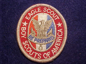 EAGLE RANK, TYPE 12D, WHITE BORDERS ON WHITE STRIPE BETWEEN RED AND BLUE, WIDE OVAL KNOT BELOW SCROLL, SCOUT STUFF IMPRINT OVER GAUZE PLASTIC BACK, 2002-